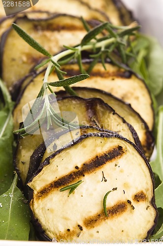 Image of Grilled eggplant slices on a plate with fresh rosemary