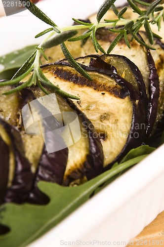 Image of Grilled eggplant slices on a plate with fresh rosemary