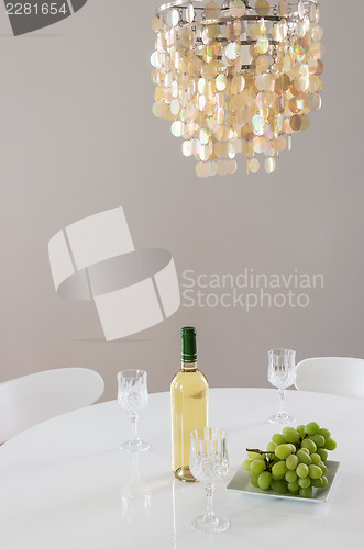 Image of Decorative chandelier and bottle of wine on the table