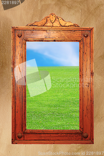 Image of wood frame with idyllic scene on wall