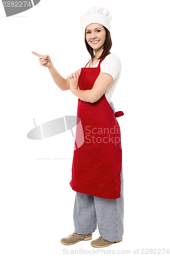 Image of Female chef pointing towards copy space area