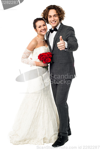 Image of Groom with his bride showing thumbs up sign