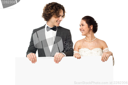 Image of Married couple posing with a blank ad board