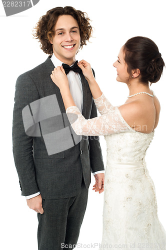Image of Bride adjusting her man's bow tie