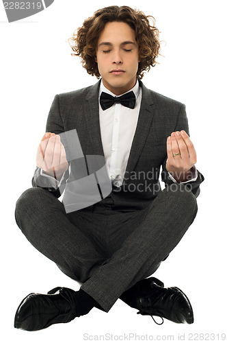 Image of Guy in tuxedo striking a lotus posture