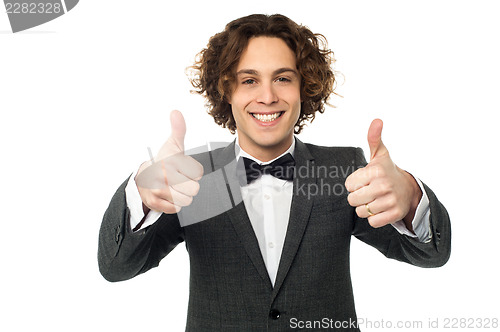 Image of Joyous young guy gesturing double thumbs up