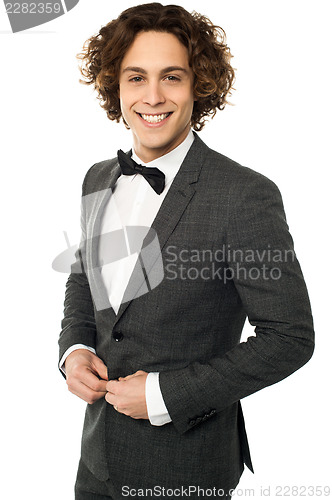 Image of Young groom buttoning up his blazer