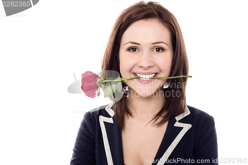 Image of Young female holding rose between her teeth