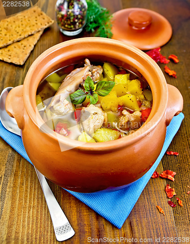 Image of Roast chicken in a clay pot on a board