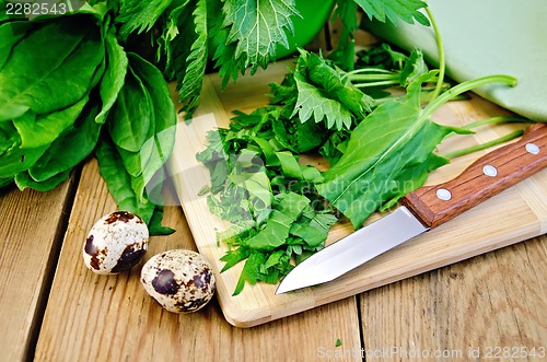 Image of Sorrel and nettles chopped on the board with quail eggs