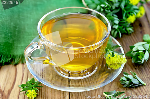 Image of Herbal tea in a glass cup with Rhodiola rosea on the board