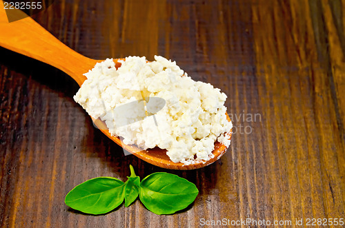 Image of Curd in a wooden spoon on the board