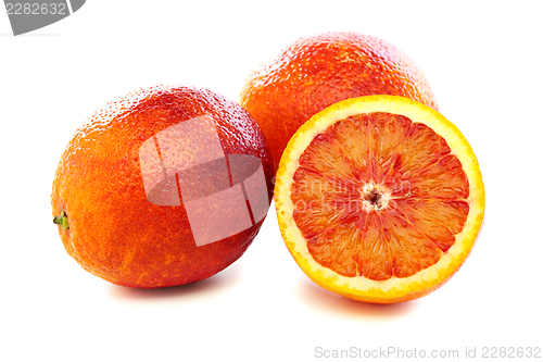 Image of Full and half of blood red oranges.