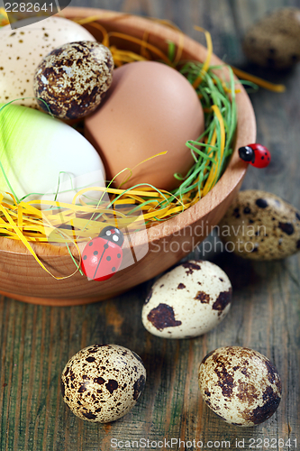 Image of Easter eggs in a bowl on old wooden. 