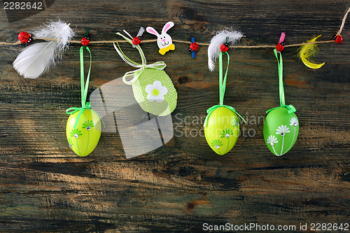 Image of Easter eggs and feathers hanging on a rope.