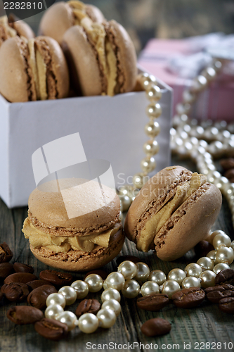 Image of Macaroons in the box, pearls and coffee beans.