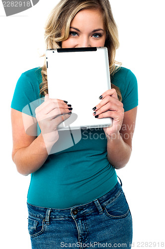 Image of Shy pretty model hiding face with tablet pc