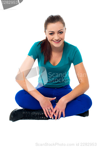 Image of Trendy girl in casuals relaxing on studio floor