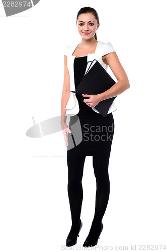 Image of Young corporate woman holding files