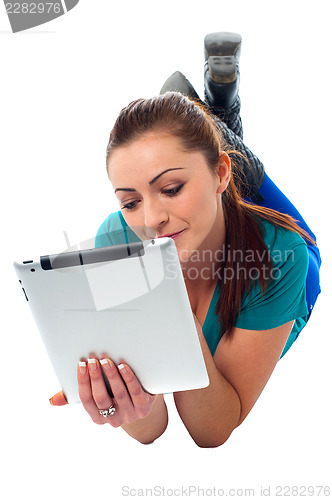 Image of Relaxed young woman surfing on tablet device