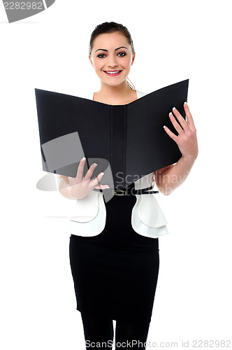 Image of Fashionable businesswoman reviewing a file