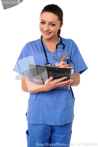 Image of Cheerful female physician writing prescription