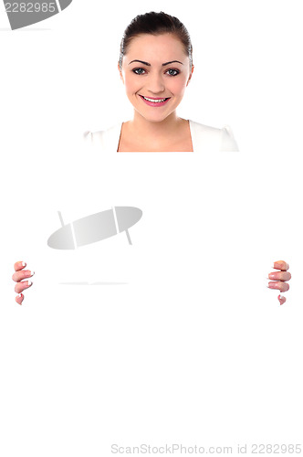 Image of Smiling woman holding blank white ad board