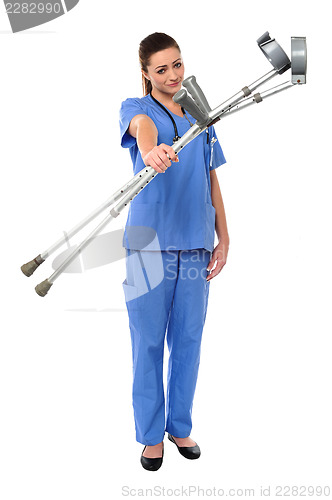 Image of Sullen faced doctor displaying crutches