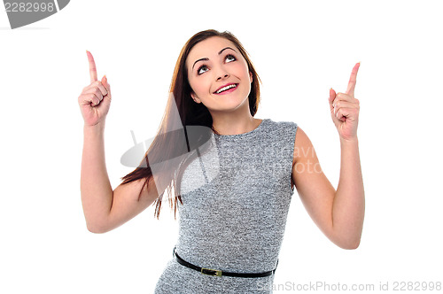 Image of Amused young girl in sleeveless dress