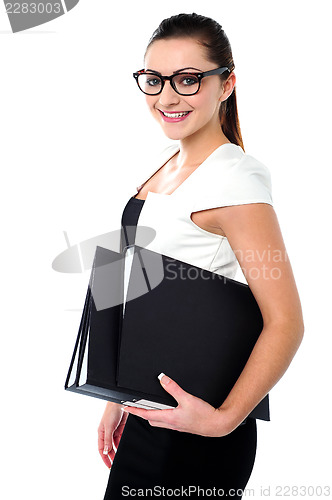 Image of Young business professional posing with folders