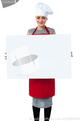 Image of Young baker woman holding a blank whiteboard