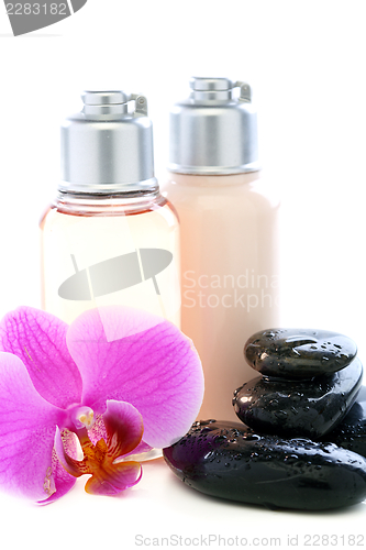 Image of Bottles with cosmetics, stones and orchid