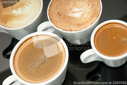 Image of four white coffe cups on the black background