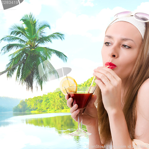 Image of Caucasian woman drinks unrecognizable cocktail