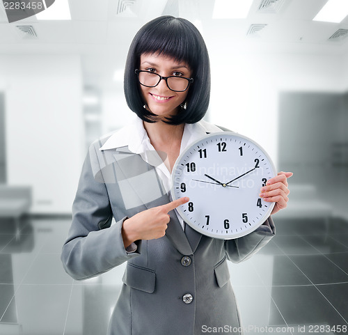 Image of office worker  holding big clock