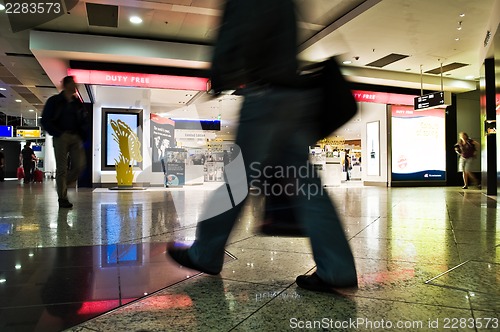 Image of blurred motion  against unrecognizable stores background 