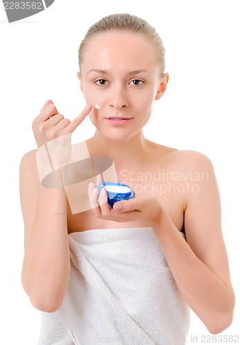 Image of woman applying cream to her face