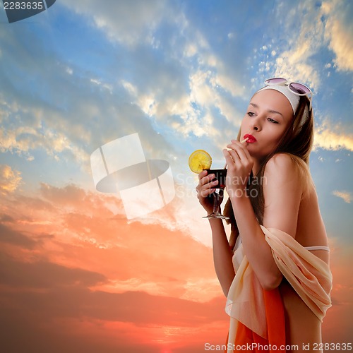 Image of Caucasian woman drinks unrecognizable cocktail