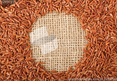 Image of Brown rice on burlap fabric