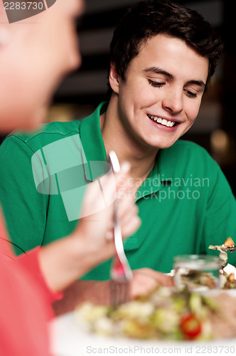 Image of Handsome young guy enjoying meal in restaurant