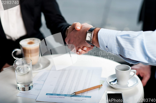 Image of Business handshake over a coffee