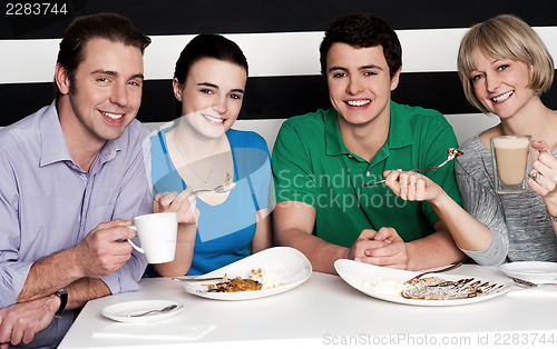 Image of Happy family of four at restaurant