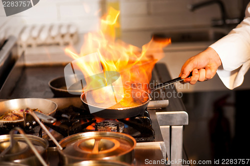Image of Chef cooking in kitchen stove