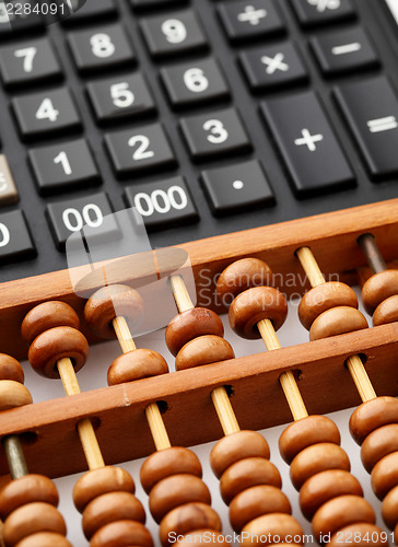 Image of Ancient abacus and modern calculator