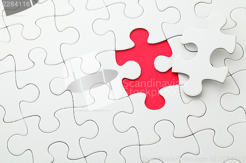 Image of Puzzle with missing piece in red color 