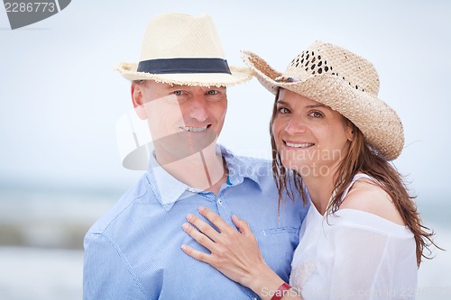 Image of happy adult couple in summertime on beach 