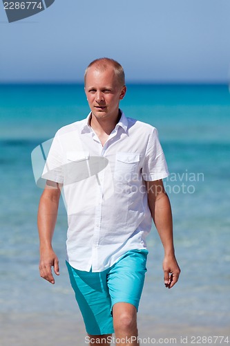 Image of young man walking on the beach in holiday