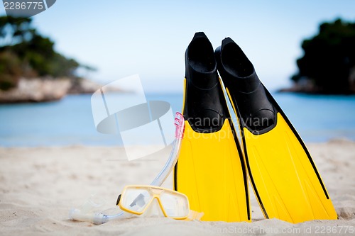 Image of yellow fins and snorkelling mask on beach in summer