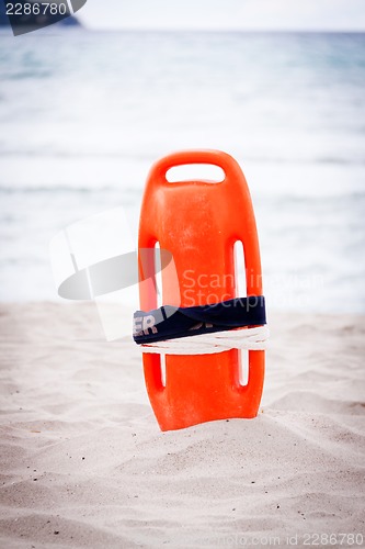 Image of orange red life buoy in sand on beach at the sea object