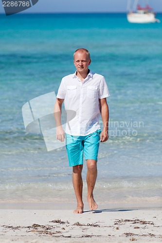 Image of young man walking on the beach in holiday